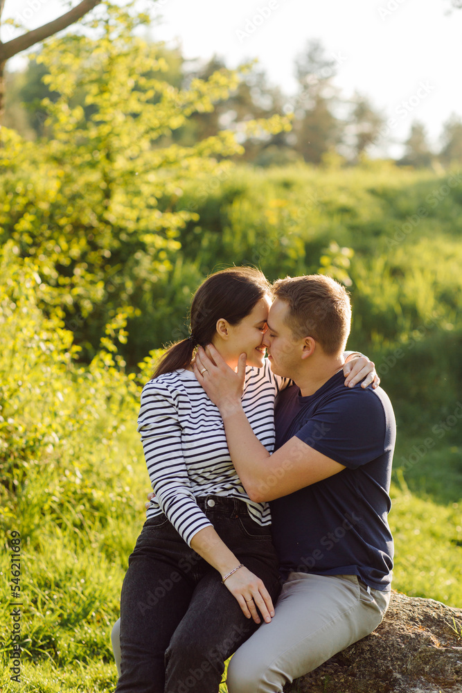 Fototapeta premium A young couple in love walks in the woods, having a good time together