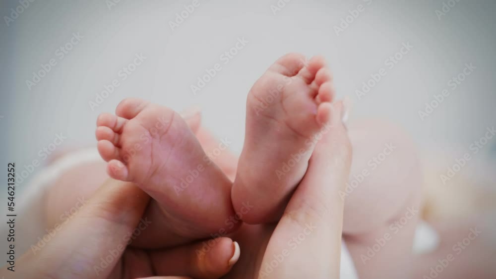 A young mother's hands play with her child's legs in the morning A young mother's hands play with her child's legs in the morning