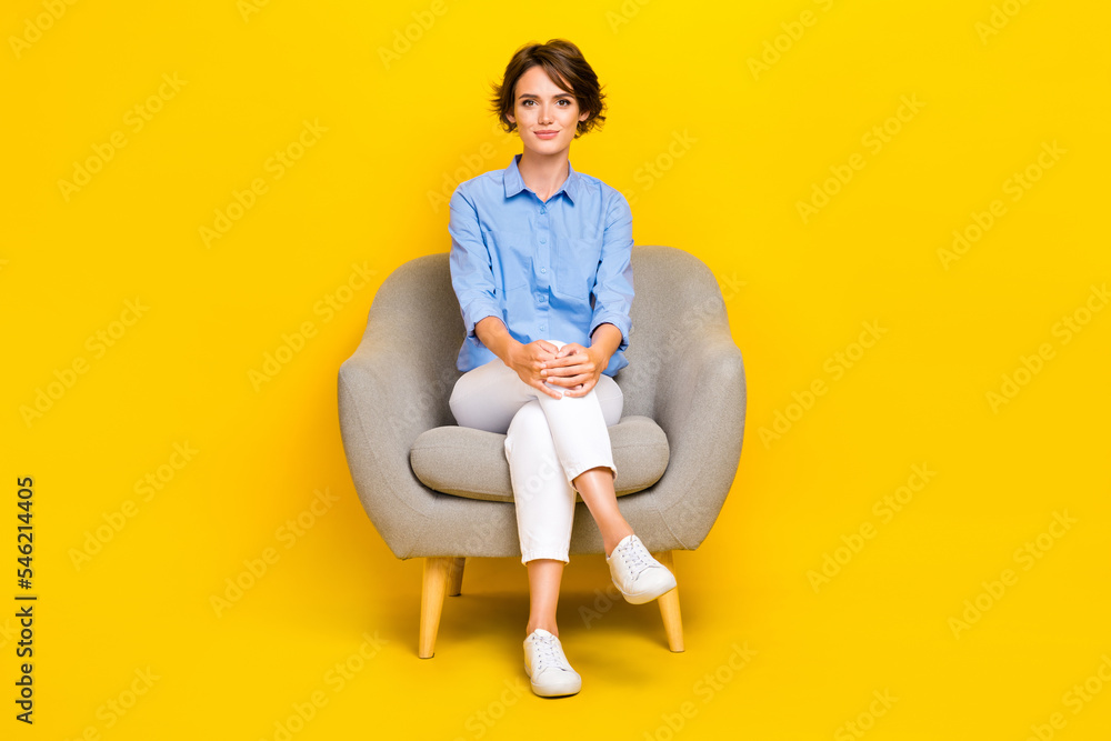 Obraz premium Full length photo of serious confident girl dressed blue having rest sofa isolated yellow color background