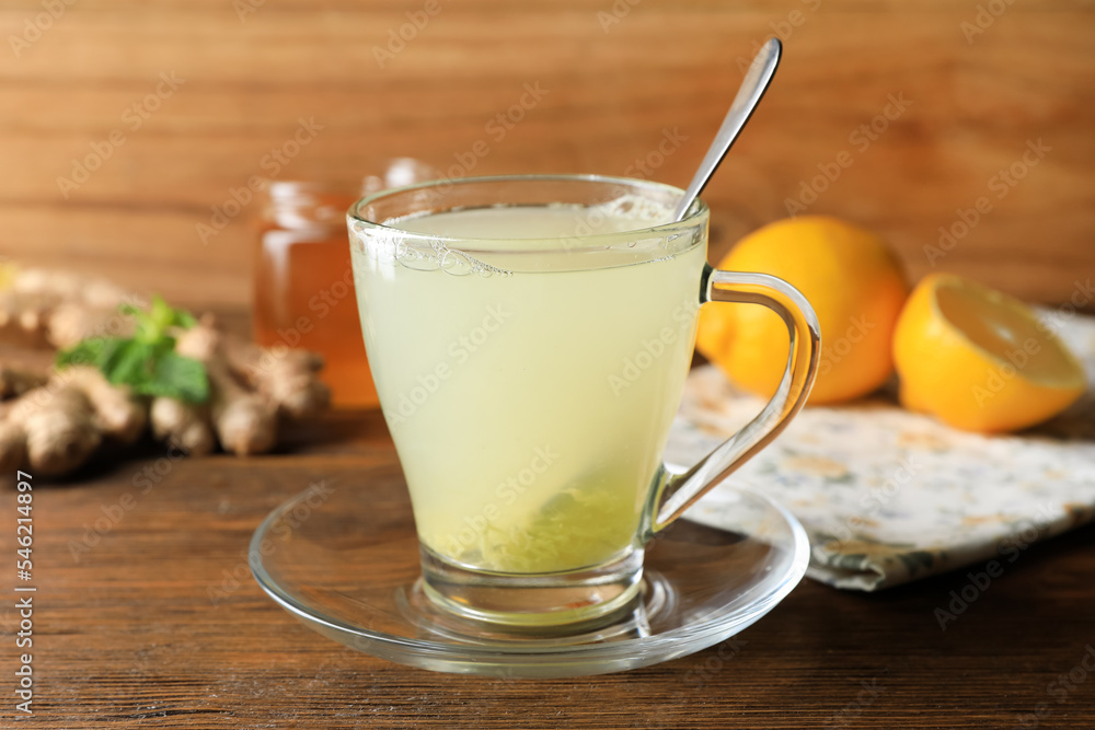 Cup of ginger tea and ingredients on wooden table Cup of ginger tea and ingredients on wooden table