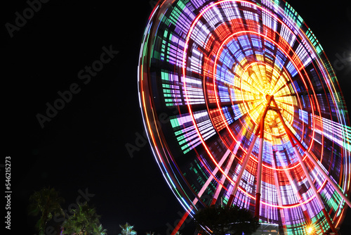 Beautiful glowing Ferris wheel against dark sky, low angle view. Space for text