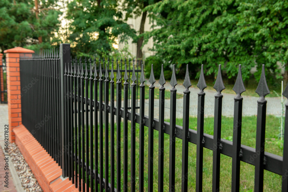Beautiful brick fence with iron railing outdoors Beautiful brick fence with iron railing outdoors