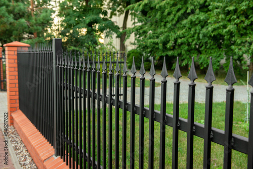 Beautiful brick fence with iron railing outdoors