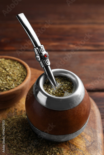 Calabash with mate tea and bombilla on wooden table