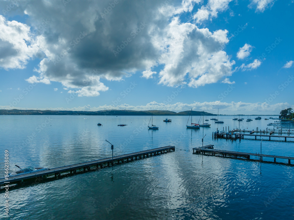 Morning waterfront views with clouds, boats and the blue lake water.