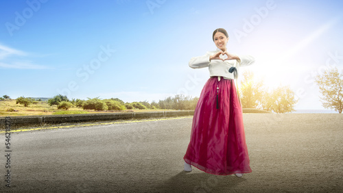 Asian woman wearing a traditional Korean national costume, Hanbok, standing on the street