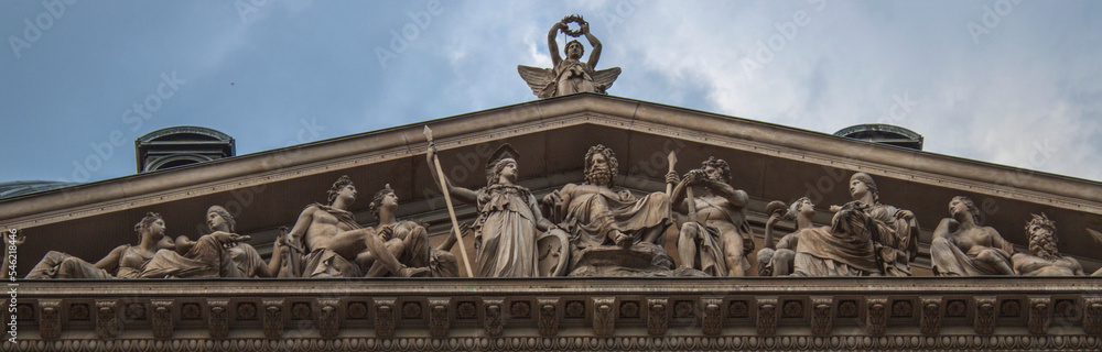 Tympanum of the ancient University of Vienna. Facade of the historical building in the old town of Vienna, Austria, Central Europe. Statues, sculptures, figures, ornaments, architectural background.