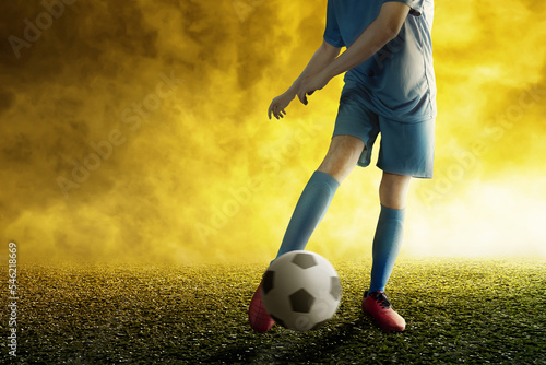 Football player man in a blue jersey kicking the ball © Leo Lintang
