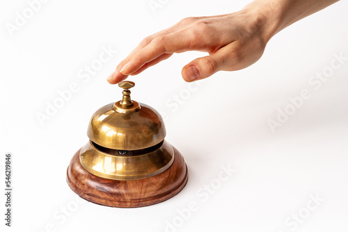 Metal golden hotel service bell with hand. Attention concept