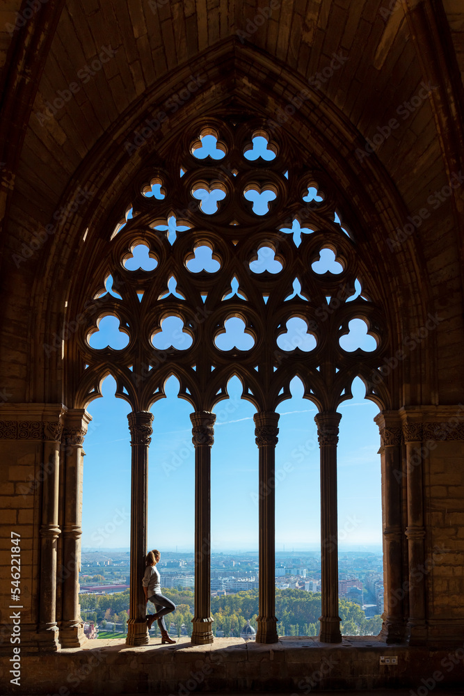 woman standing on colonnade of cloister window- Lerida in Catalonia