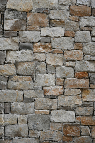 Fondo con detalle y textura de pared con multitud de piedras en diferentes formas y tamaños, en tonos marrones y grises