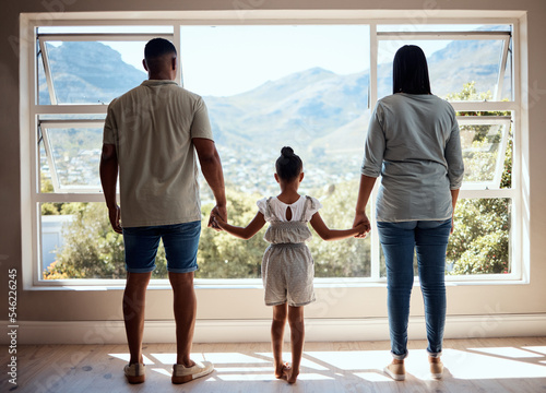 Family, child or girl by window in new house, home or apartment with mortgage loan, finance security or future investment property. Mother, father and kid as real estate homeowner with mountains view
