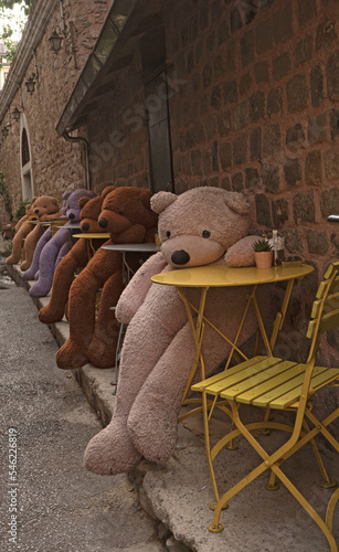 Plush bears sitting  at at coffee’s chairs