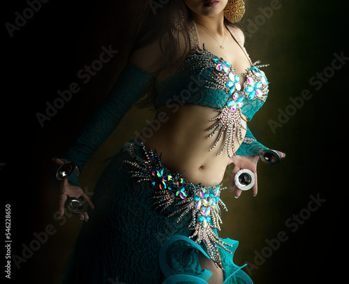 Belly dancer with finger cymbals and turquoise dress with sequins photo