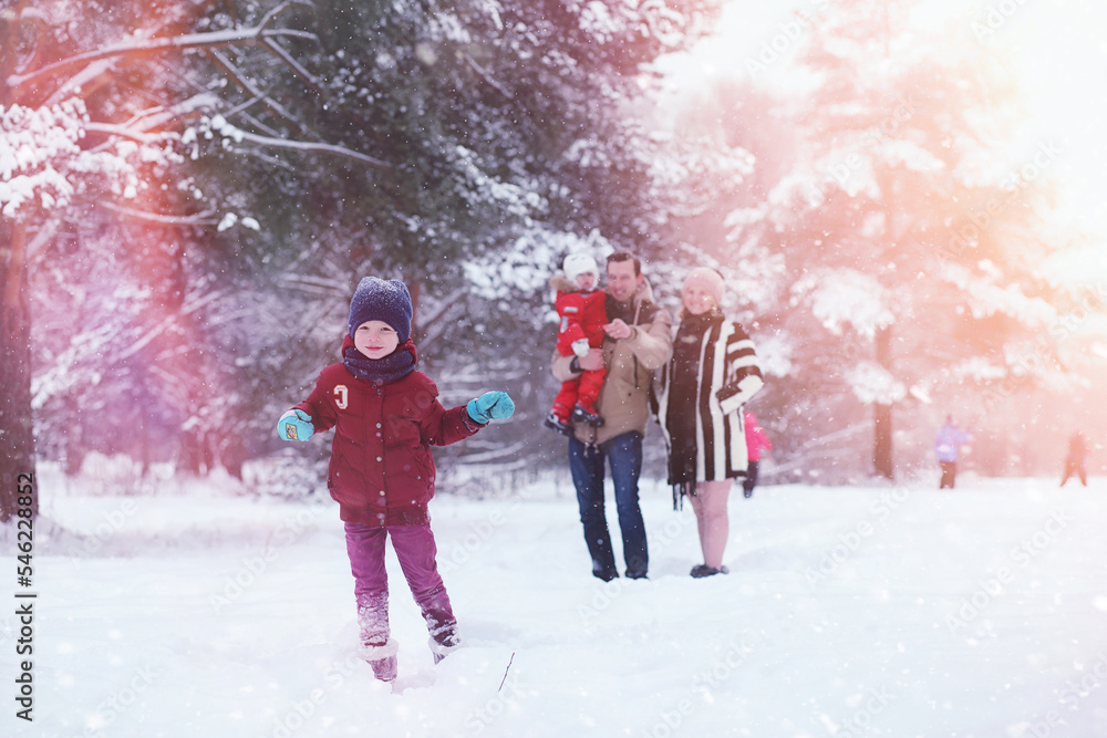 Young family with children are walking in the winter park. Winter walk of parents with children. Walking on a holiday weekend in the winter. Young family with children are walking in the winter park. Winter walk of parents with children. Walking on a holiday weekend in the winter.