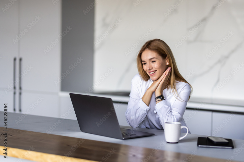 Happy young woman using laptop in cook room Happy young woman using laptop in cook room