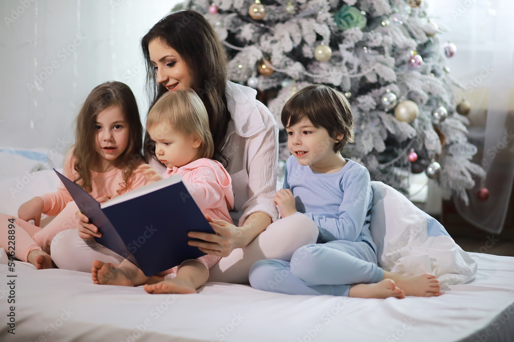 A family with children having fun on the bed under the covers during the Christmas holidays. A family with children having fun on the bed under the covers during the Christmas holidays.