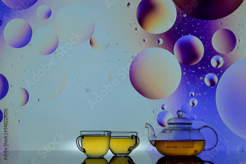 transparent teapot with tea glasses on a colored background