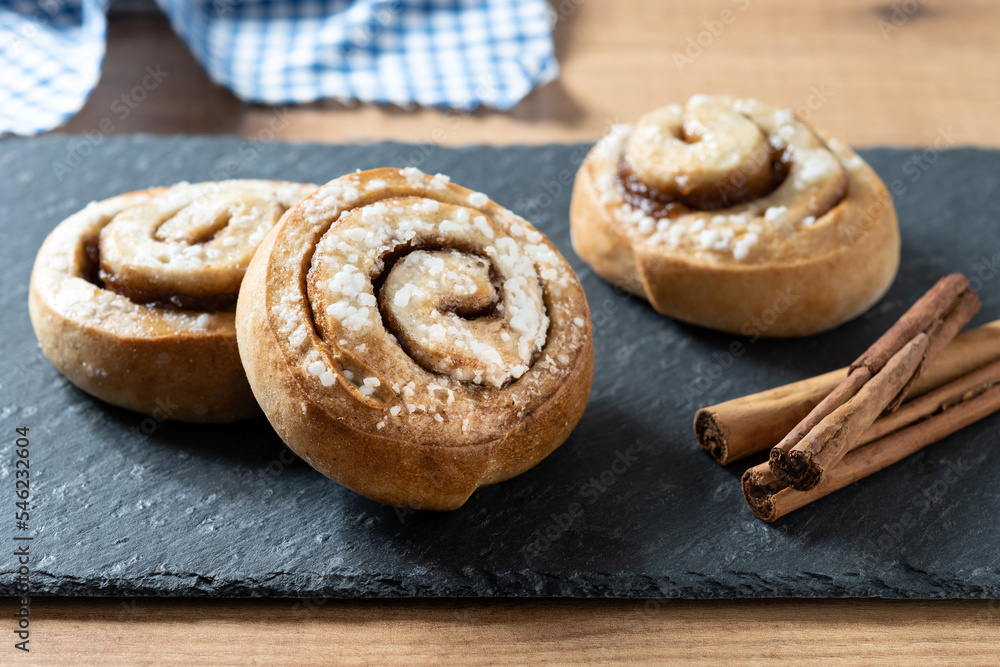 Cinnamon rolls buns on wooden table. Kanelbulle Swedish dessert Cinnamon rolls buns on wooden table. Kanelbulle Swedish dessert