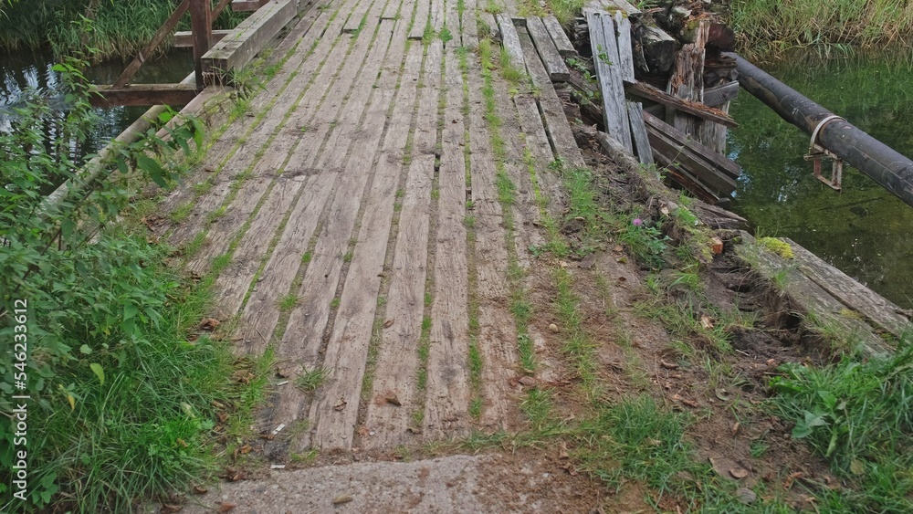 Old Damaged Collapsed Wooden Bridge over Shallow River 