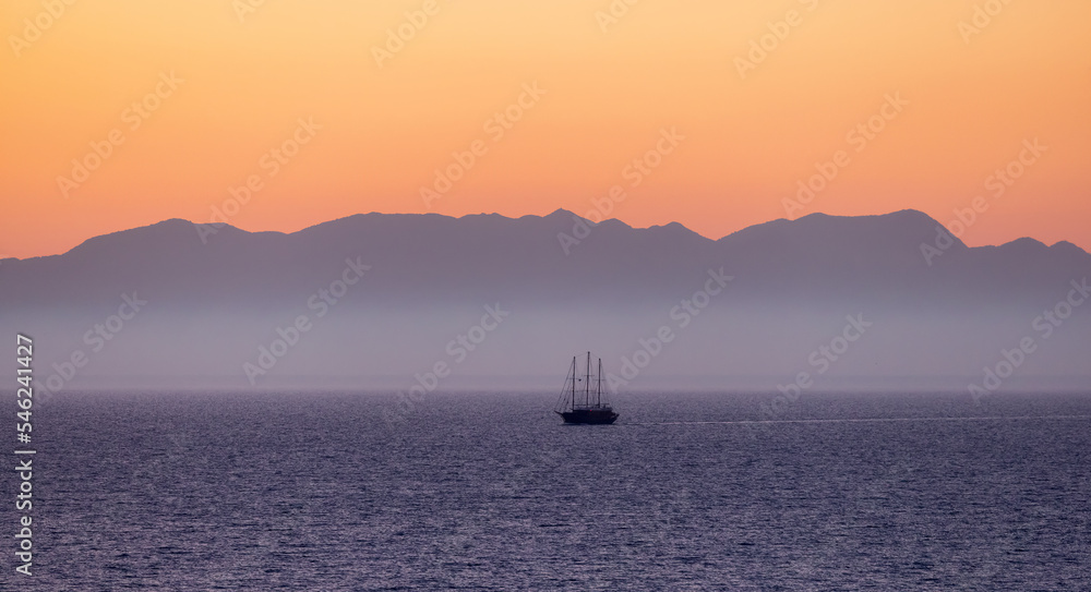 Sailboat in the Ionian Sea with Mountain Landscape Background. Twilight Sunrise Sky. Katakolo, Greece.