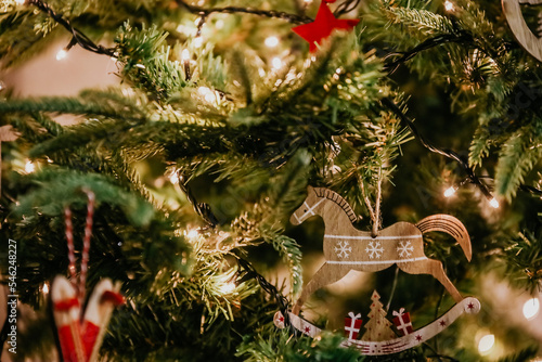 Defocused blurred close up of Christmas toys on christmas tree with lights and other decorations