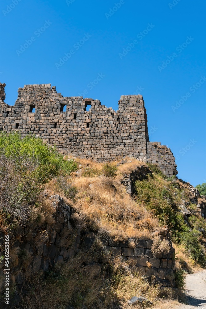 Armenia, Amberd, September 2022. The ruins of the walls of an ancient fortress against the sky.