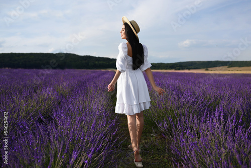 Fototapeta Naklejka Na Ścianę i Meble -  Beautiful young woman walking in lavender field