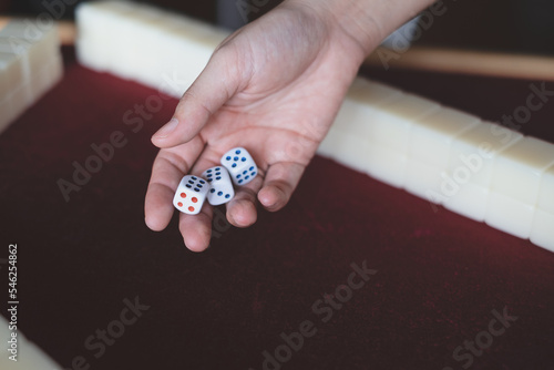 Photography Hands rolling dice, playing Mahjong game