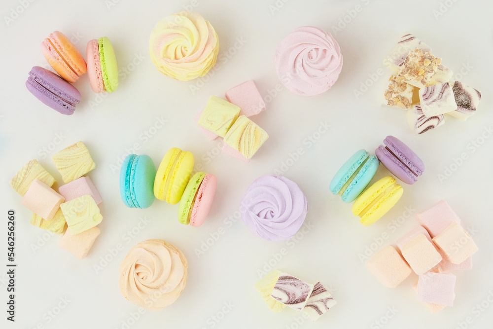 Obraz premium Various of desserts: macaroons, marshmallows and zephyrs, closeup. Traditional colored sweet desserts for the holiday. Top view.