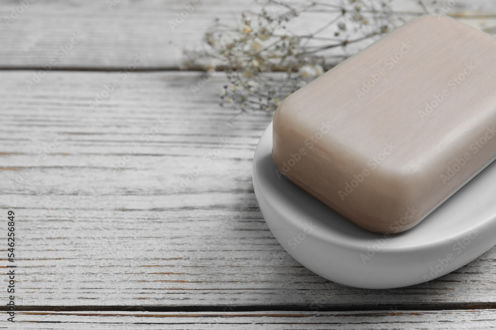 Dish with soap bar on wooden table, closeup. Space for text Dish with soap bar on wooden table, closeup. Space for text