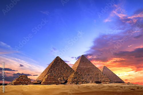 Fotografiet Great Pyramids of Giza, Egypt, at sunset travel concept