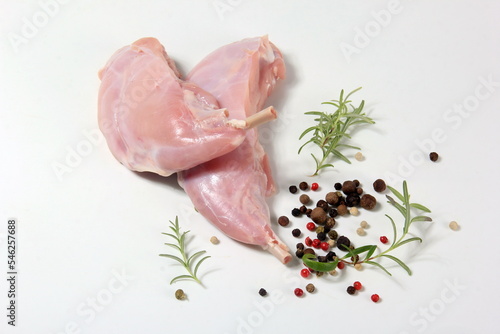 raw rabbit legs with bone with peppercorns on a white background