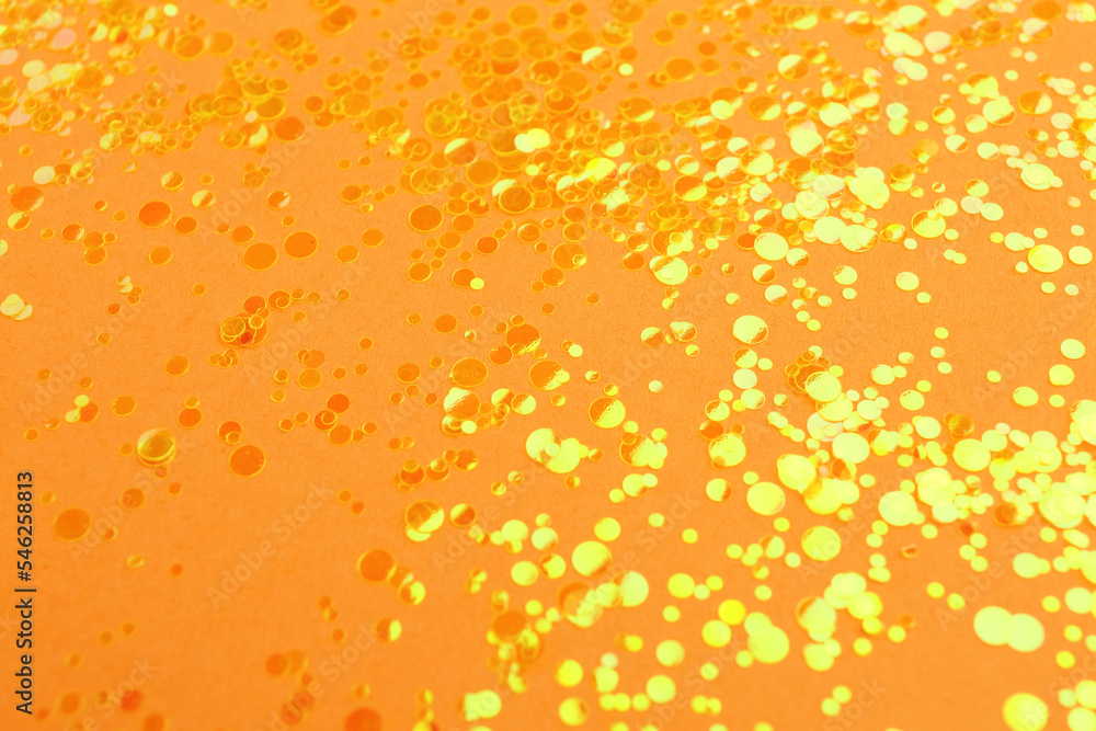 Shiny bright yellow glitter on pale coral background