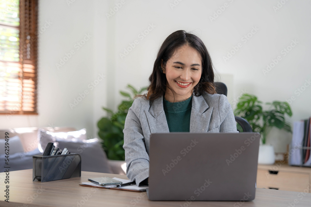 Asian Business woman using calculator and laptop for doing math finance on an office desk, tax, report, accounting, statistics, and analytical research concept Asian Business woman using calculator and laptop for doing math finance on an office desk, tax, report, accounting, statistics, and analytical research concept