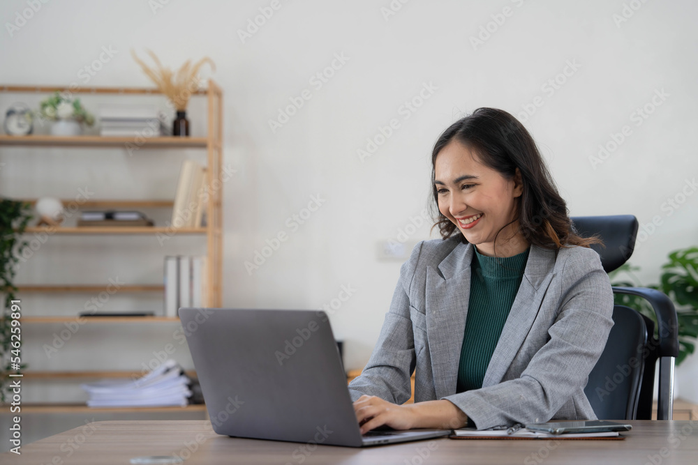 Asian Business woman using calculator and laptop for doing math finance on an office desk, tax, report, accounting, statistics, and analytical research concept Asian Business woman using calculator and laptop for doing math finance on an office desk, tax, report, accounting, statistics, and analytical research concept