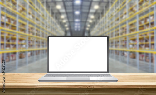laptop with blank screen standing on a wooden table in a storehouse, mockup concept
