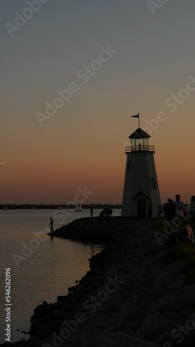 Wallpaper Mural Steady vertical footage of a lighthouse, with silhouettes of unrecognizable people at sunset Torontodigital.ca