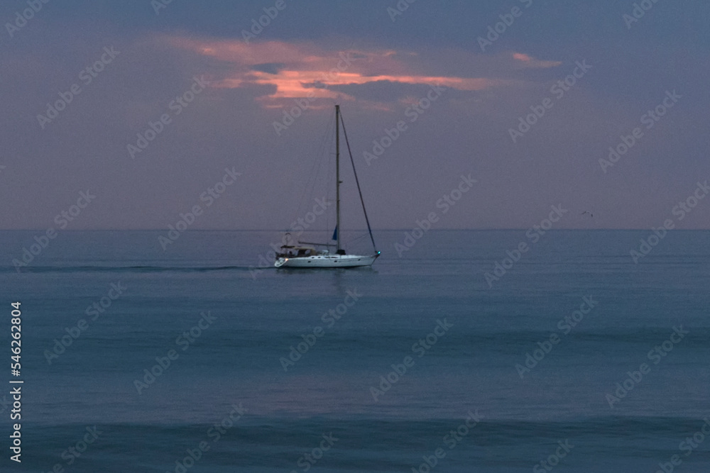 Little sailboat sailing on the Atlantic ocean at sunset, Maspalomas, Gran Canary, Canary Islands, Spain