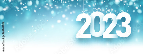 Banner with hanging 2023 sign on blue snowing background.