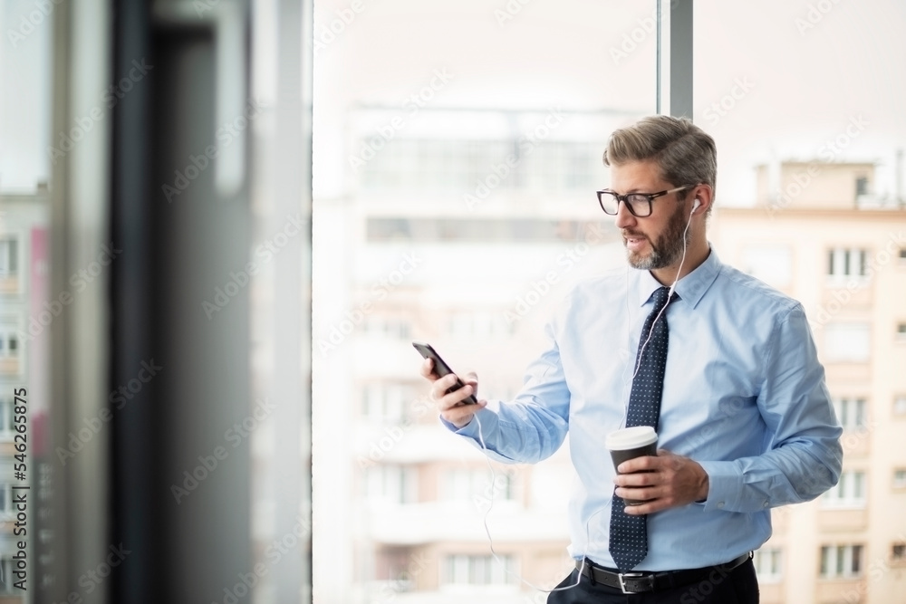 Middle aged  businessman using cell phone and text messaging
