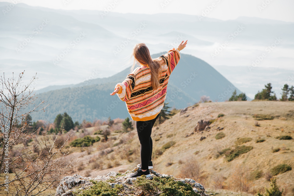 Obraz premium Woman standing on the rock among the mountains at sunny day in the forest in Turkey Bolu. Hiking concept.