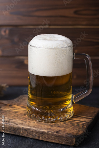 fresh cold beer in a glass on wooden board