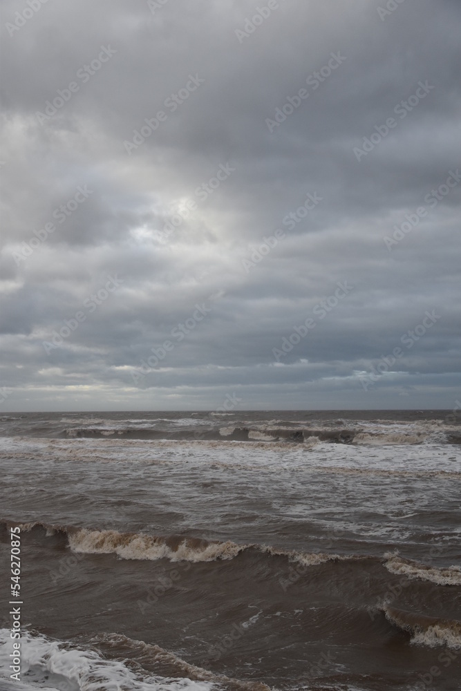 Waves crashing onto the beach and sea wall during high tide. Taken in Cleveleys Lancashire England. 