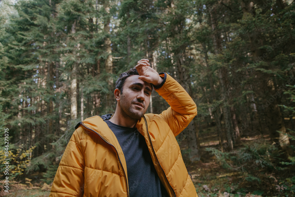 Man walking in the forest in autumn in a yellow jacket. Hiking concept. Man walking in the forest in autumn in a yellow jacket. Hiking concept.