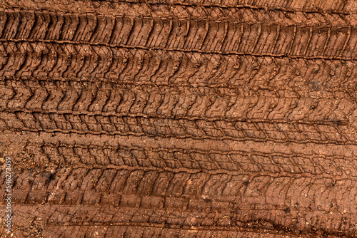 Tyre track on dirt sand or mud, Picture in retro or grunge tone. Car drive on sand. off road track. Track on grass field. Track in farm.