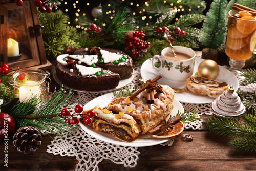 Christmas strudel with poppy seeds and chocolate poppy cake with apple on festive table