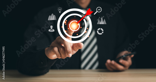 Businessman pointing to target icon on virtual screen. Startup business. Goal Setting Ideas, Objectives and Investment Goal Ideas