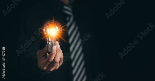 Businessman with light bulb to illuminate, Innovative technology in science and communication concept. New ideas and innovations with light bulb.