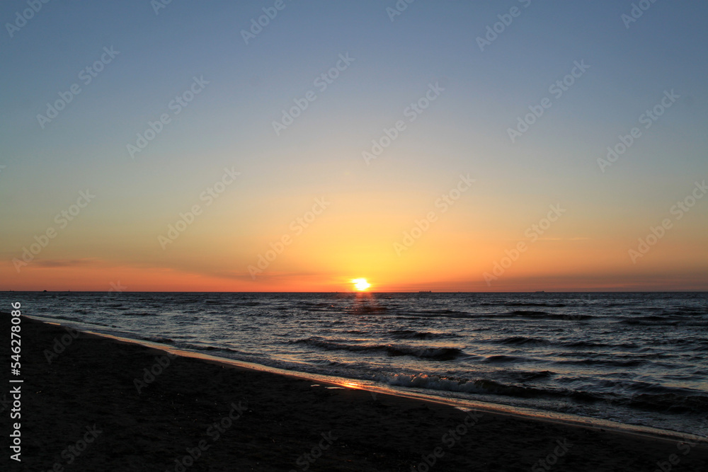 Bronze sunsetting sky above a slightly wavy sea. Selective focus